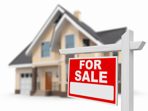 For Sale sign in front of suburban house
