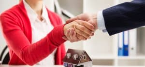 Shaking hands over mortgage documents