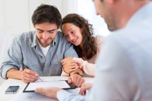 Young attractive couple signing contract